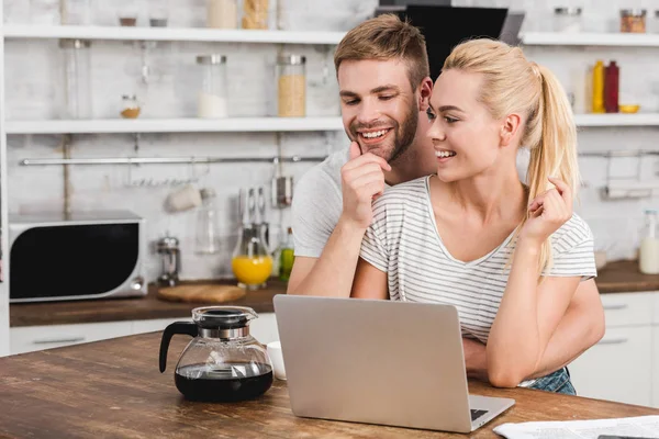 Novio Feliz Abrazar Novia Cocina Mientras Que Ella Usando Ordenador — Foto de Stock