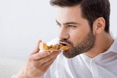 Genç adam yeme yalnız pizza evde portresi