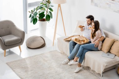 genç çiftin evde tv izlerken pizza yemek yüksek açılı görünüş