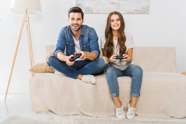 Sonriente Joven Pareja Jugando Videojuego Por Joysticks Sofá Casa — Foto de Stock