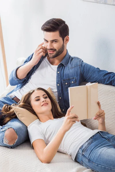 Sonriente Hombre Hablando Teléfono Inteligente Mientras Que Novia Leer Libro — Foto de stock gratuita