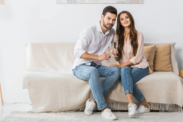 Happy Young Couple Celebrating Champagne Glasses Sofa Home — Stock Photo, Image