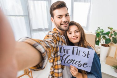 Kamera bakış açısı, bizim ilk ev kartı alma selfie birlikte yeni evde çiftle gülümseyen