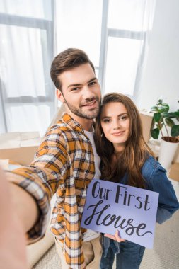 Kamera bakış açısı, bizim ilk ev kartı alma selfie birlikte yeni evde çiftle gülümseyen