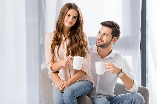 自宅でコーヒーのカップを持つカップルを愛する若者の肖像 — ストック写真