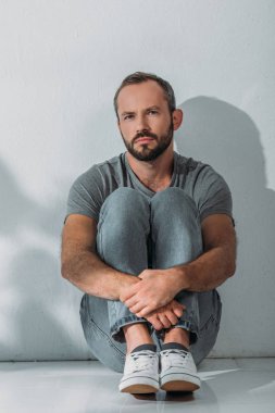 depresif görünümünü tam uzunlukta katta oturan ve kameraya bakarak orta yaşlı adam sakallı 