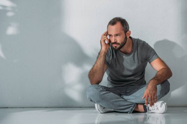katta oturan ve uzağa bakarak orta yaşlı adam üzgün görünümünü tam uzunlukta sakallı