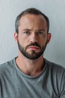 yakın çekim gri kameraya bakarak sinirli sakallı adam portresi 