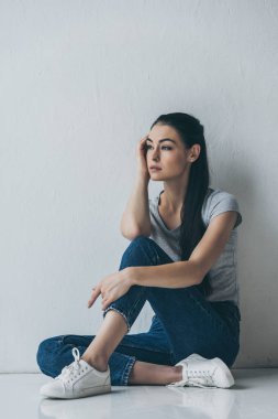 full length view of beautiful frustrated brunette woman sitting and looking away  clipart