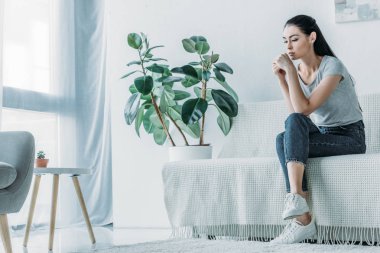 güzel üzgün genç kadın evde koltukta oturan-depresyon