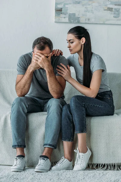 Young Woman Supporting Sad Boyfriend Sitting Couch Hands Face — Stock Photo, Image