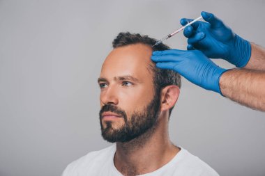 Enjeksiyon alopesi ile seyir uzağa gri izole adama veren şırınga ile doktor doz kırpılmış  