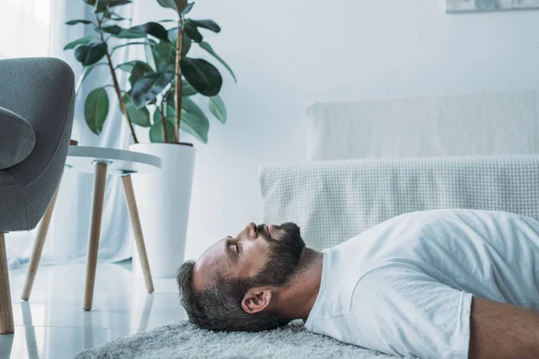 Samping Melihat Pria Berjanggut Depresi Berbaring Karpet Dan Melihat Atas — Stok Foto