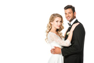 kucaklayan ve üzerinde beyaz izole kamera bakarak yeni evliler gülümseyen
