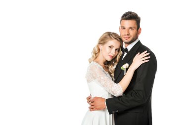 kucaklayan ve üzerinde beyaz izole kamera bakarak Genç yeni evliler