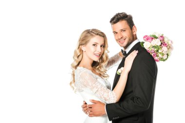 kucaklayan ve üzerinde beyaz izole kamera bakarak mutlu yeni evliler