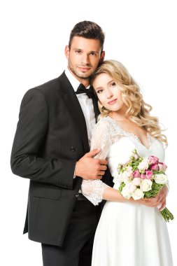güzel genç gelin ve damat kucaklayan ve kameraya bakarak beyaz izole