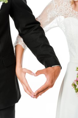 Gelin ve damat elleri üzerinde beyaz izole işareti kalp yapma çekim kırpılmış