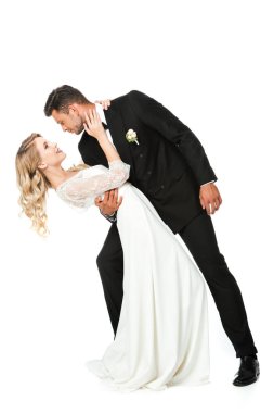 tutkulu Genç gelin ve damat dans sırasında kucaklayan ve birbirlerine beyaz izole bakarak