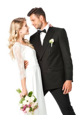 mutlu genç gelin ve damat dans sırasında kucaklayan ve birbirlerine beyaz izole bakarak