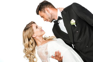 güzel genç gelin ve damat dans sırasında kucaklayan ve birbirlerine beyaz izole bakarak