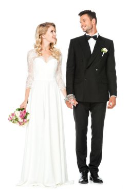 güzel genç gelin ve damat elele ve birbirlerine beyaz izole bakarak