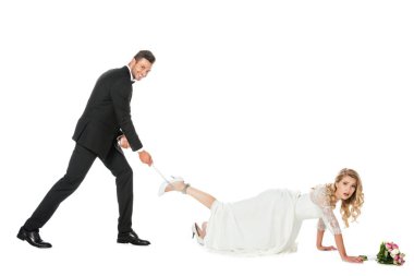 mutlu damat gelinler bacağın etrafında bağlı ve kamera üzerinde beyaz izole bakarak zinciri tutarak