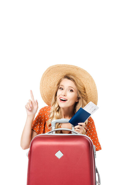 beautiful girl holding passport witch ticket and pointing up isolated on white