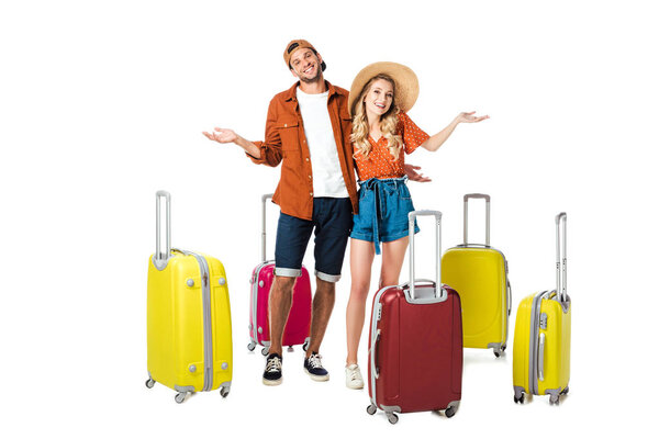 smiling newlywed couple with arranged suitcases around isolated on white