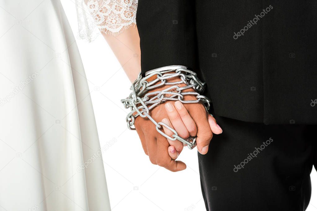 cropped shot of bride and groom holding hands tied in chain isolated on white