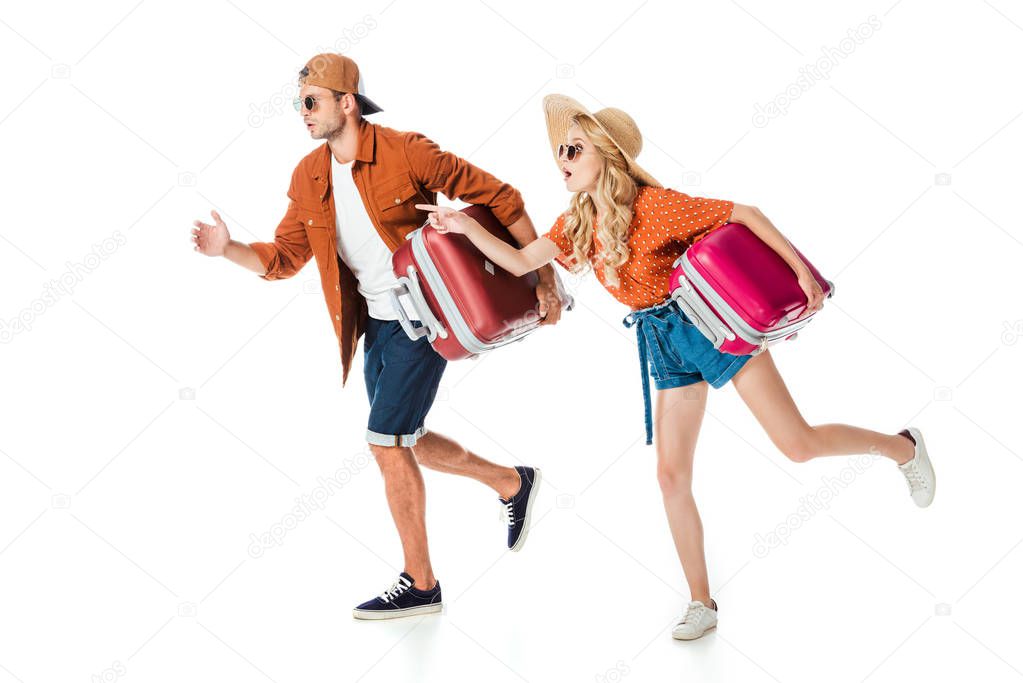 side view of shocked couple running with travel bags isolated on white