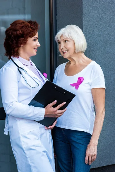 クリップボード シニア女性話して お互いに 乳房癌の概念を笑顔と医師 — ストック写真