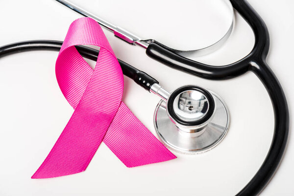 top view of pink breast cancer awareness ribbon and stethoscope isolated on white  