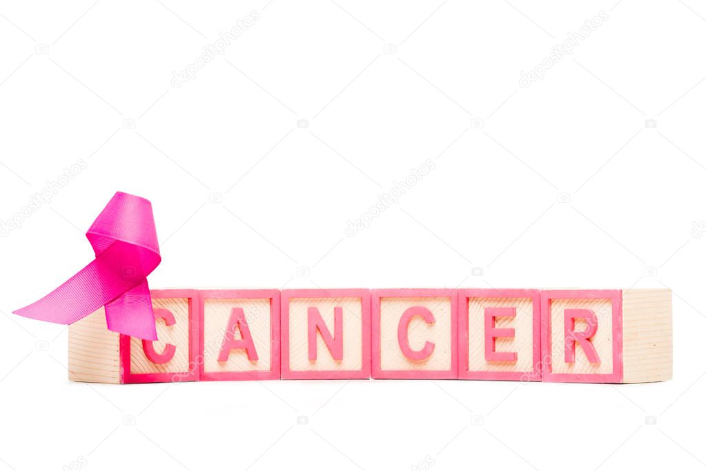 close-up view of pink ribbon and cubes with word cancer isolated on white