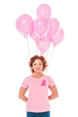 pembe balonlar demet tutarak ve beyaz, meme kanseri kavramı izole kamera gülümseyen Olgun kadın 