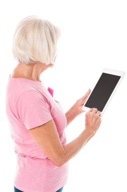 boş ekran üzerinde beyaz izole ile dijital tablet kullanarak meme kanseri bilinçlendirme şerit pembe tişört kadın kıdemli 