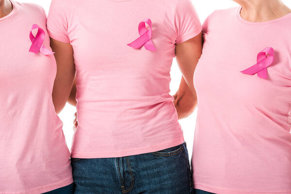 partial view of women with pink ribbons standing together isolated on white, breast cancer awareness concept 
