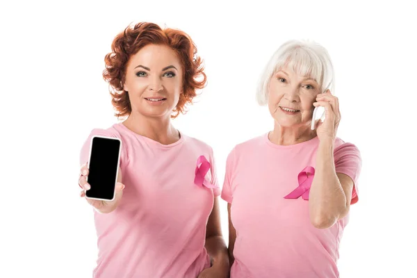 Mujeres Con Cintas Color Rosa Utilizando Teléfonos Inteligentes Sonriendo Cámara — Foto de stock gratis