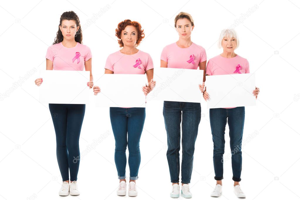 women in pink t-shirts with breast cancer awareness ribbons holding blank banners and looking at camera isolated on white 