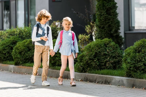 Bonito Pouco Alunos Com Mochilas Mãos Dadas Caminhando Juntos Rua — Fotografia de Stock