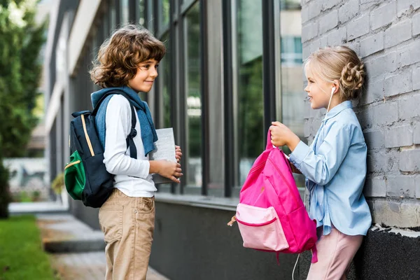 Lindo Poco Colegiales Con Mochilas Sonriendo Uno Otro Fuera — Foto de Stock