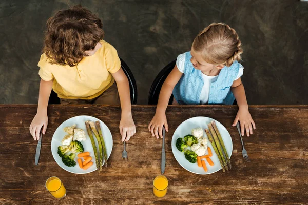 Високий Кут Зору Чарівних Дітей Їдять Здорові Овочі Дивляться Один — стокове фото