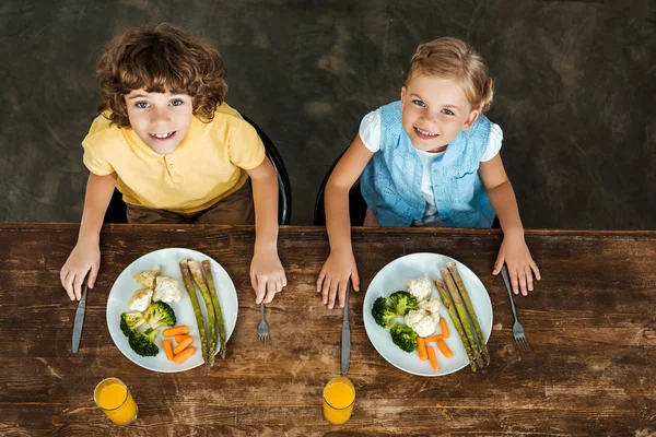 Magas Szög Kilátás Imádnivaló Boldog Gyerekek Egészséges Zöldségeket Eszik Mosolyogva — Stock Fotó