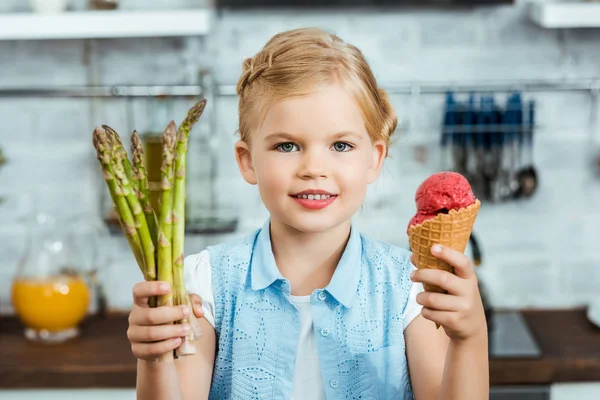 カメラに微笑んで 幸せな子をかわいいおいしいアイス クリーム コーンと アスパラガスの健康保持 — ストック写真