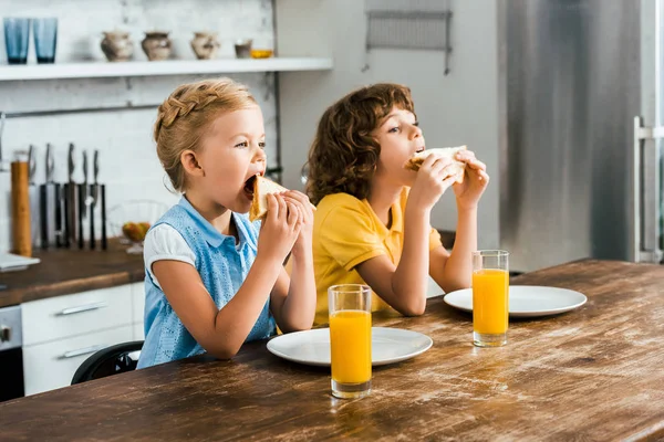 Crianças Bonitas Sentadas Mesa Comendo Sanduíches Saborosos — Fotografia de Stock