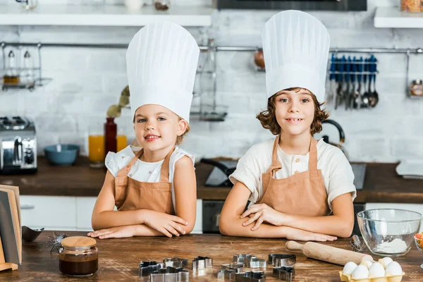 Lindos Niños Felices Delantales Sombreros Chef Sonriendo Cámara Mientras Cocinan — Foto de Stock