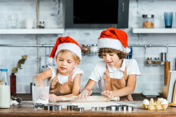 Bedårande Chldren Santa Hattar Och Förkläden Förbereder Julkakor Tillsammans — Stockfoto