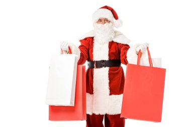 elinde kağıt torbalar ile Noel Baba ayakta ve üzerinde beyaz izole kamera bakıyor