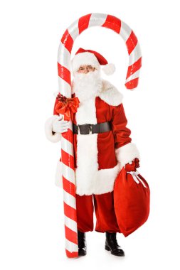 santa claus with giant candy cane and sack looking at camera isolated on white clipart