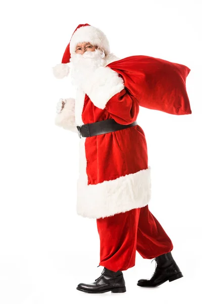 圣诞老人步行与麻袋和看在白色相机隔离的侧面视图 — 图库照片